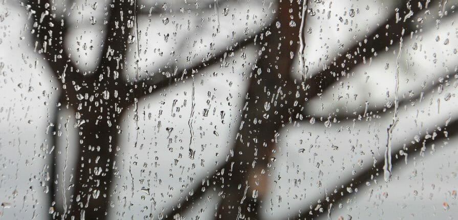 A window outfitted with Climate Seal storm window products during a storm.