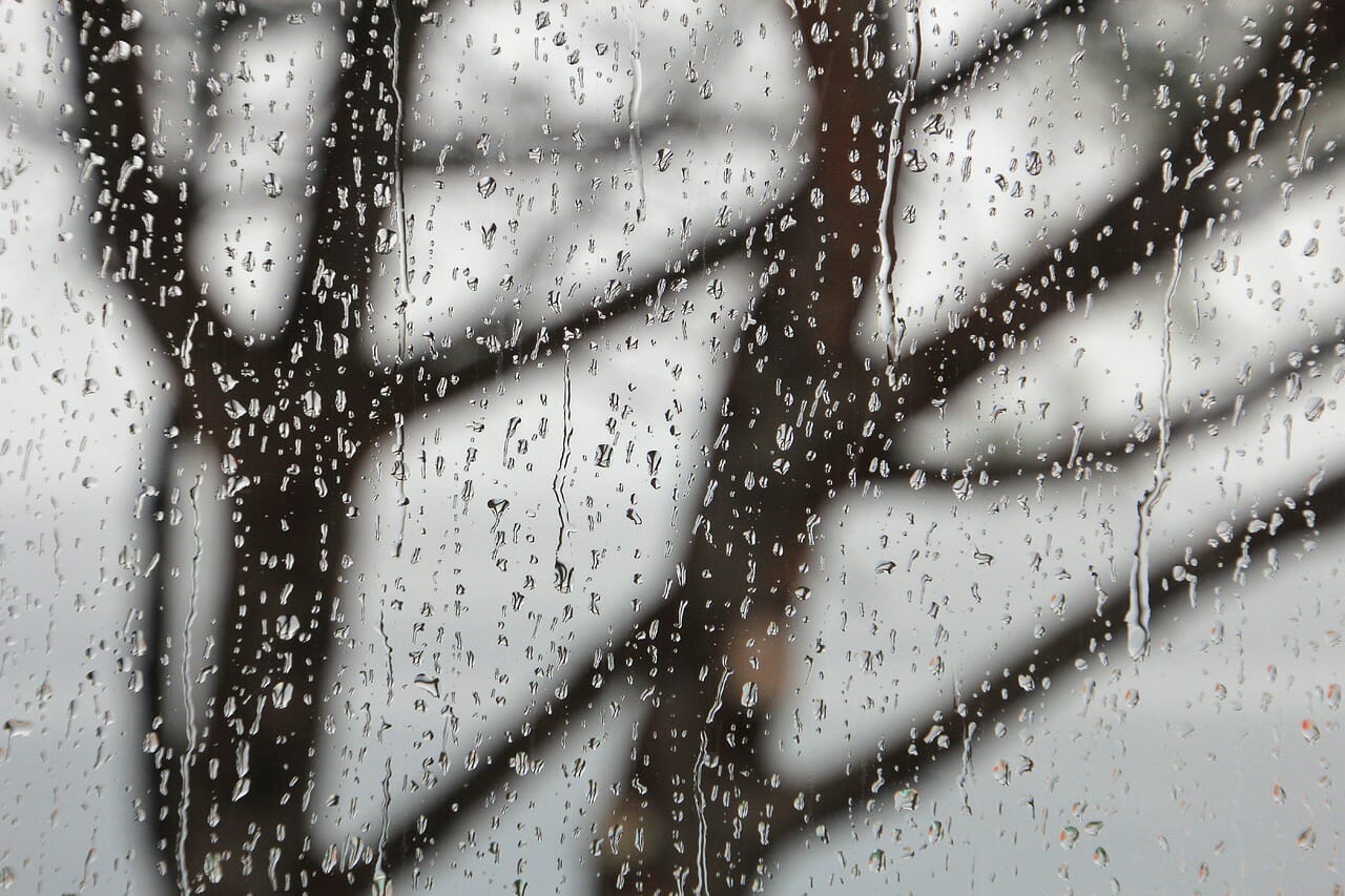 A window outfitted with Climate Seal storm window products during a storm.