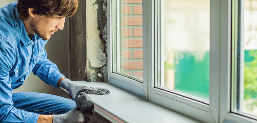 A man replaces rotted window sills with the Climate Seal Preservation Series window inserts.